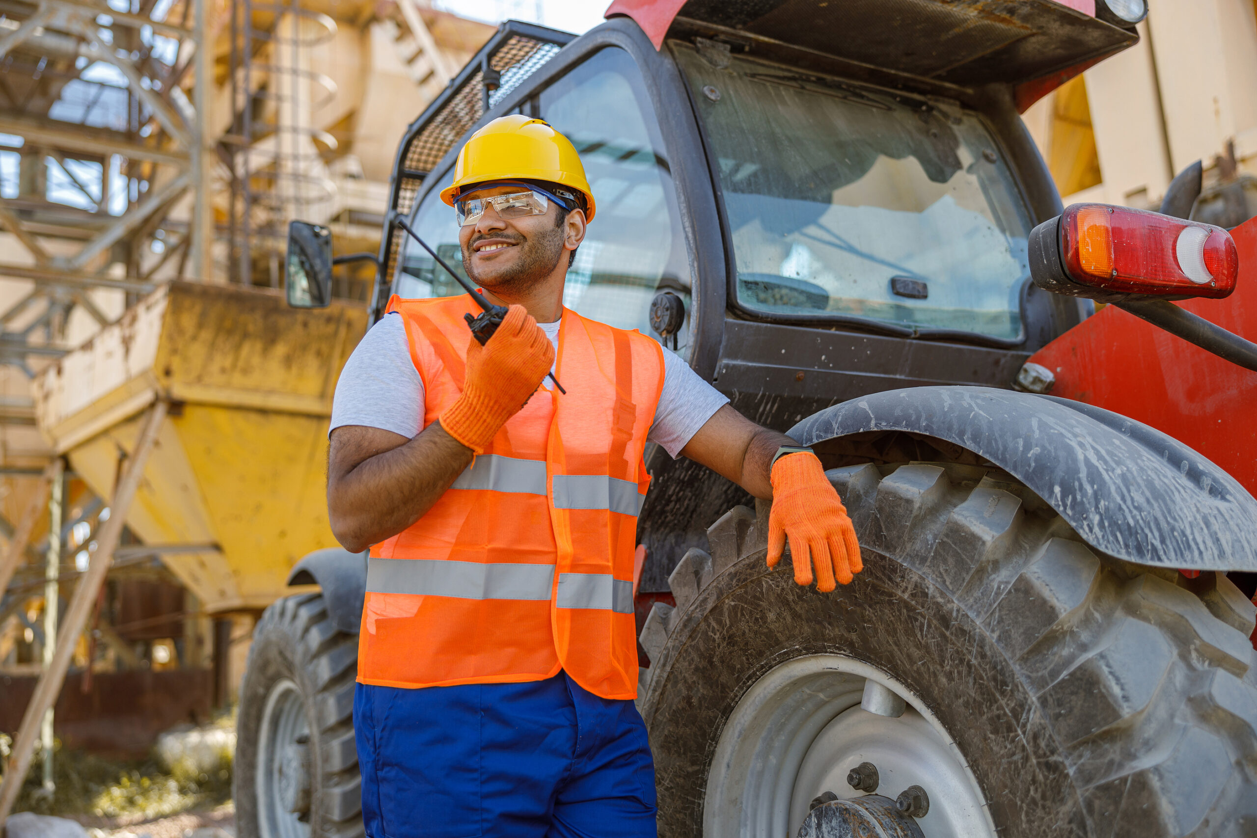 Worker In Safety Equipment Working At Construction Plant